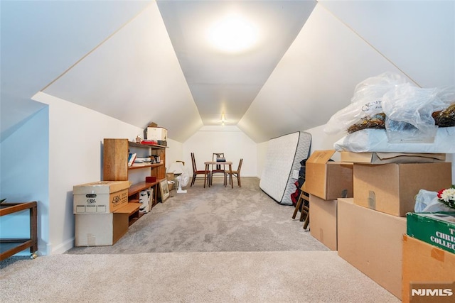 additional living space featuring vaulted ceiling and light carpet