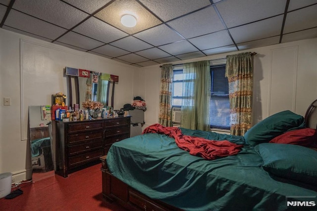 bedroom featuring carpet flooring, a paneled ceiling, and radiator