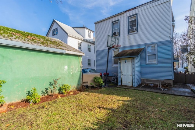 back of house featuring a yard and cooling unit