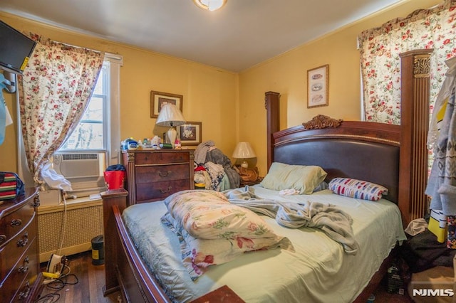 bedroom featuring radiator, cooling unit, and dark wood-type flooring