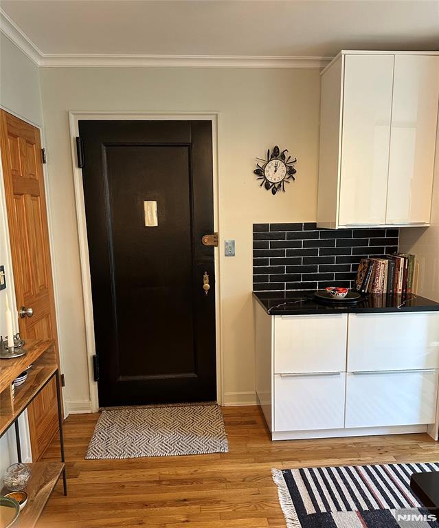 entrance foyer with light hardwood / wood-style flooring and crown molding