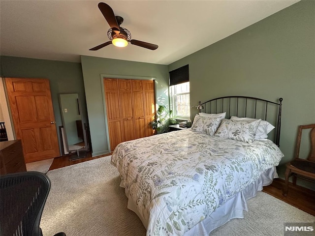 carpeted bedroom with ceiling fan and a closet