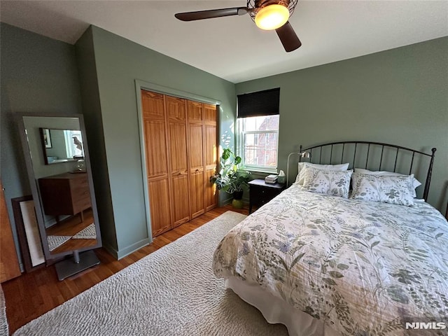 bedroom featuring ceiling fan, a closet, and hardwood / wood-style floors