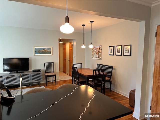 dining room featuring hardwood / wood-style flooring and crown molding