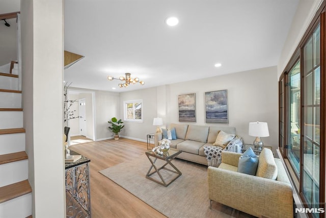 living room featuring a chandelier and light wood-type flooring