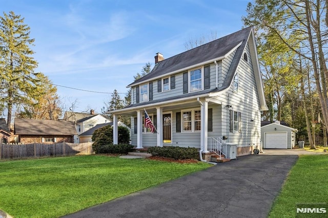 view of front of house featuring an outbuilding, a front lawn, and a garage