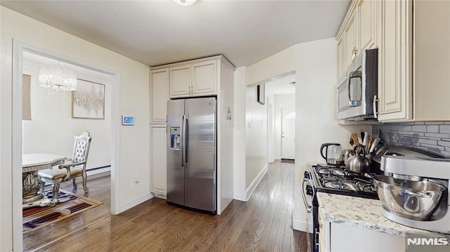 kitchen featuring an inviting chandelier, dark hardwood / wood-style floors, backsplash, decorative light fixtures, and appliances with stainless steel finishes