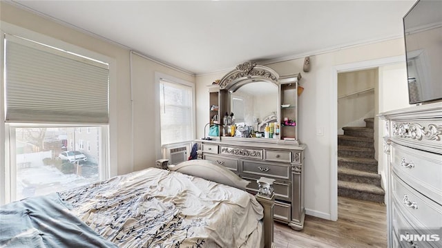 bedroom with light hardwood / wood-style flooring, cooling unit, and crown molding