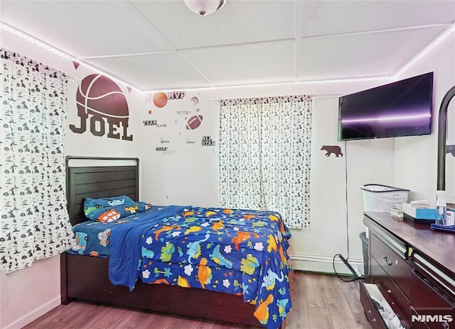 bedroom featuring hardwood / wood-style floors and a baseboard radiator