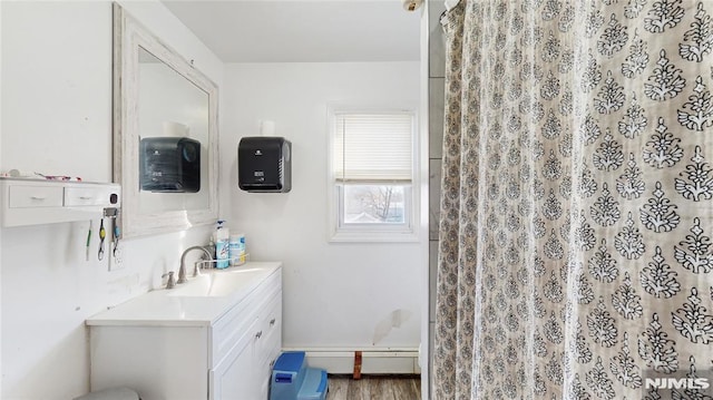 bathroom featuring baseboard heating, vanity, wood-type flooring, and walk in shower