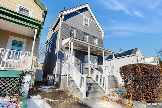 townhome / multi-family property featuring covered porch