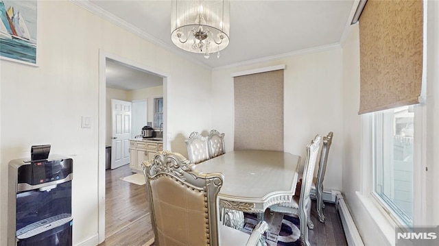 dining space featuring hardwood / wood-style floors, a notable chandelier, ornamental molding, and a baseboard heating unit