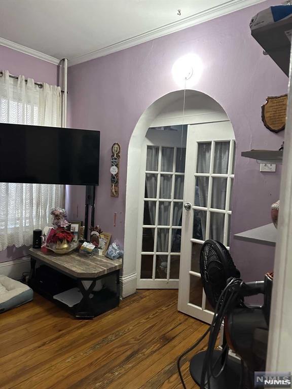 office with hardwood / wood-style floors and crown molding