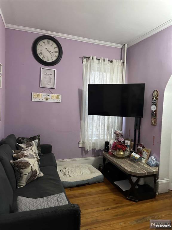 living room with wood-type flooring and crown molding