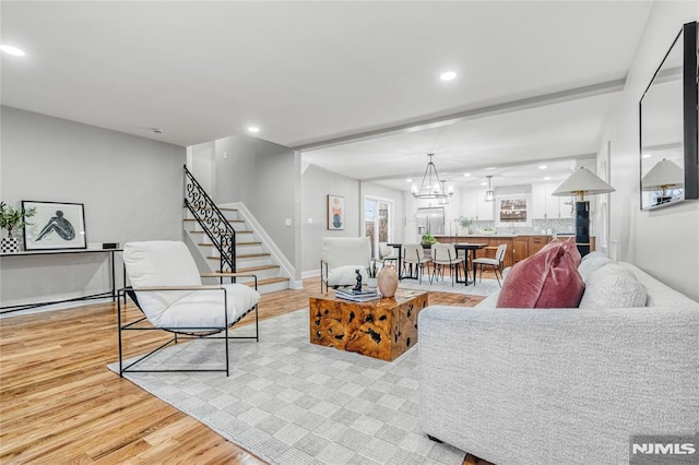 living room with light hardwood / wood-style floors, an inviting chandelier, and baseboard heating