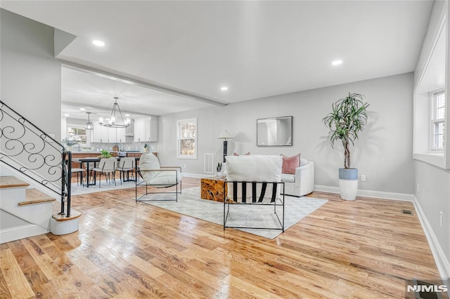 living room with light hardwood / wood-style flooring and an inviting chandelier