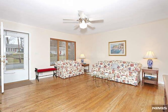 living room featuring hardwood / wood-style floors and ceiling fan