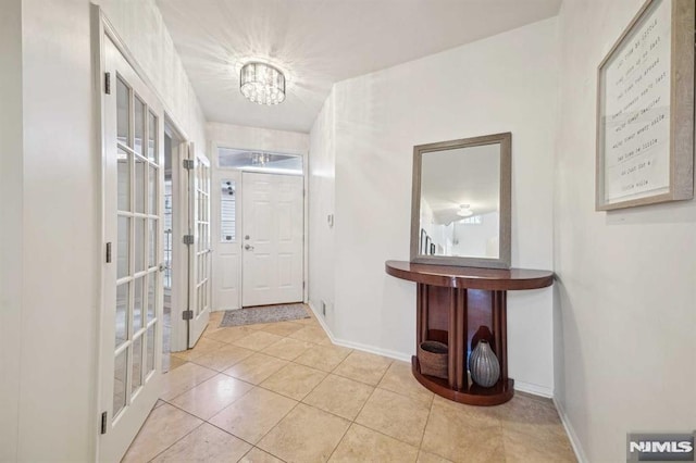 interior space featuring light tile patterned floors and a chandelier