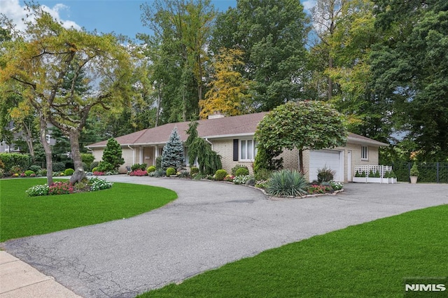 single story home featuring a garage and a front lawn