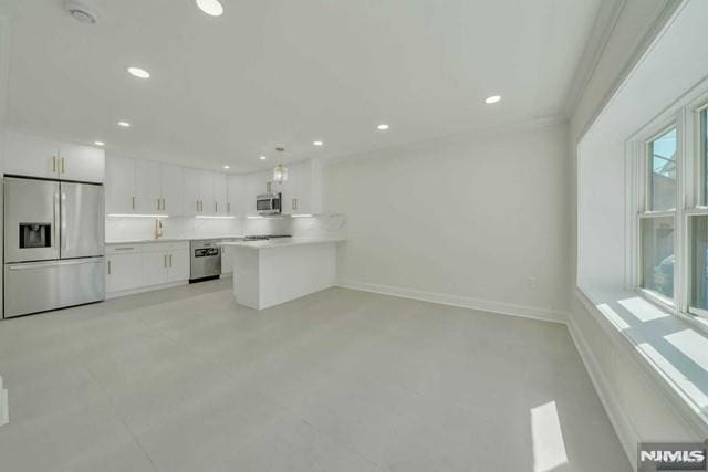 kitchen with kitchen peninsula, white cabinets, and stainless steel appliances