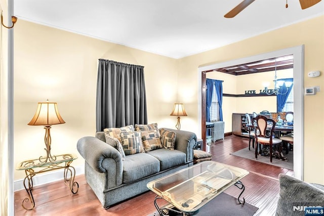 living room with hardwood / wood-style floors and ceiling fan with notable chandelier