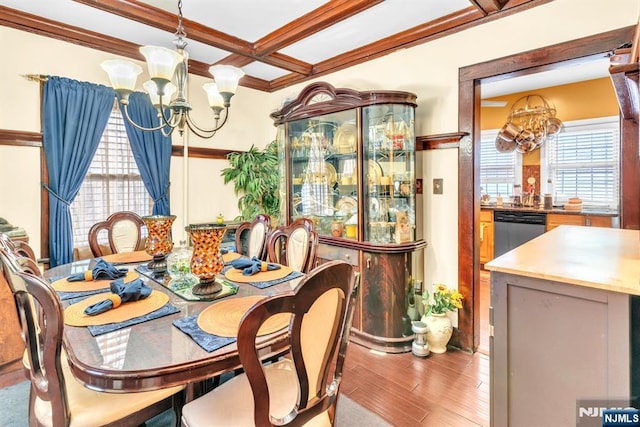 dining space featuring a healthy amount of sunlight, a chandelier, coffered ceiling, and light hardwood / wood-style floors