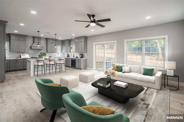 living room featuring ceiling fan and light wood-type flooring