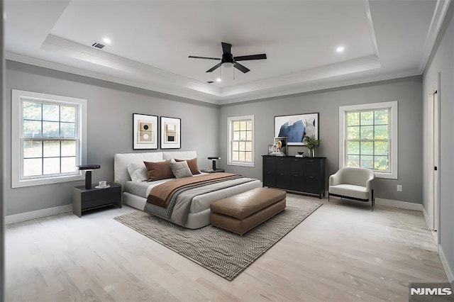 bedroom with a raised ceiling, ceiling fan, and wood-type flooring