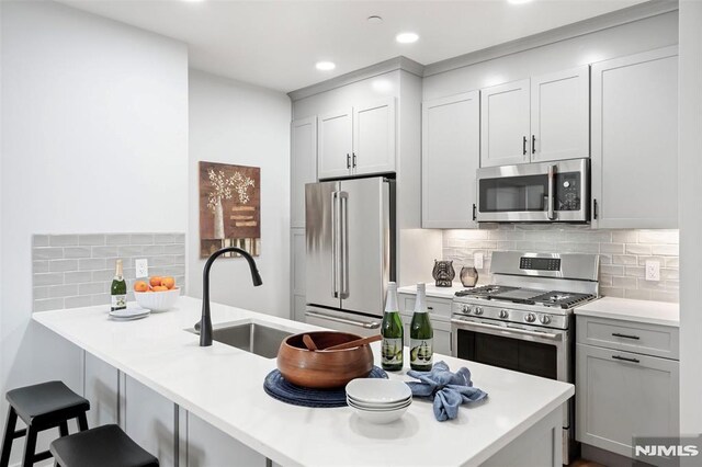 660 Bloomfield Ave Unit 402, Bloomfield, NJ 07003 - kitchen with light countertops, a sink, a kitchen bar, a peninsula, and stainless steel appliances