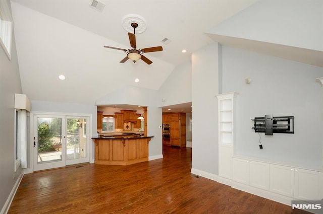 unfurnished living room featuring high vaulted ceiling, dark hardwood / wood-style flooring, and ceiling fan