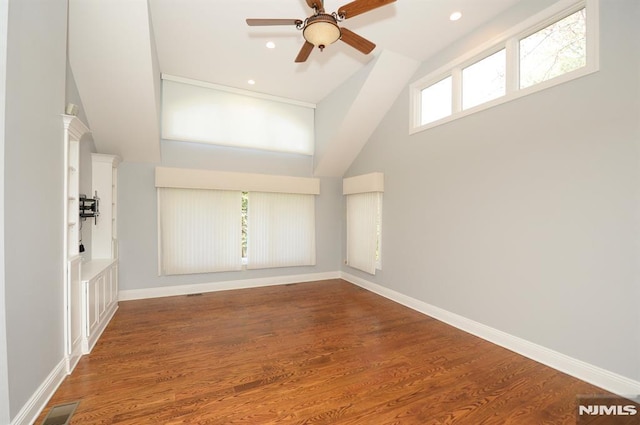 spare room with wood-type flooring, high vaulted ceiling, and ceiling fan