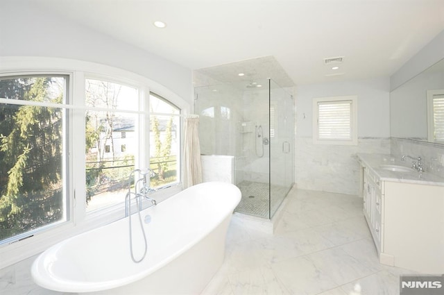 bathroom with vanity, a wealth of natural light, and independent shower and bath