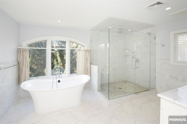 bathroom with vanity, tile walls, and plus walk in shower