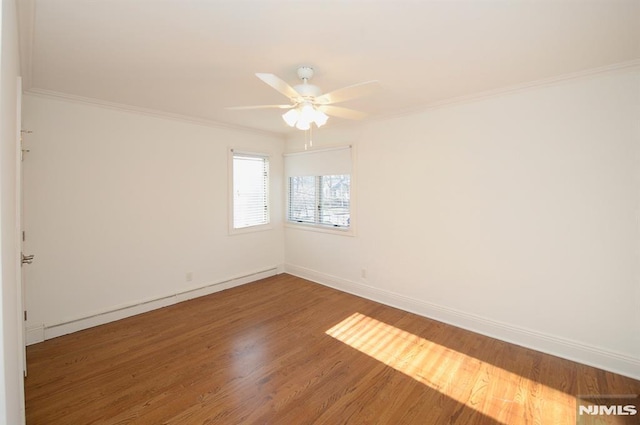 empty room with hardwood / wood-style floors, ornamental molding, and ceiling fan