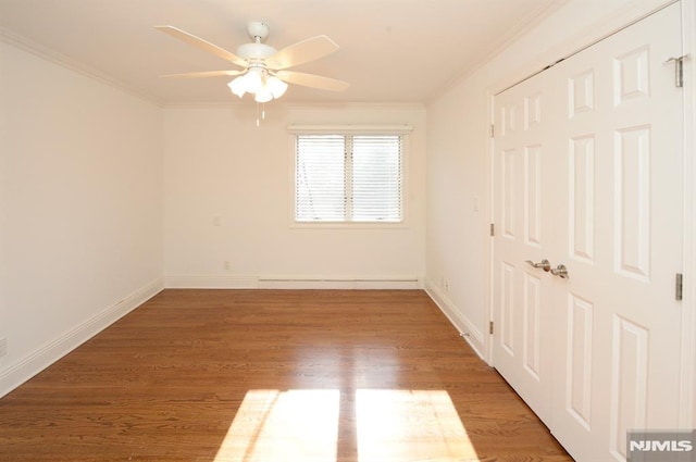 unfurnished room featuring hardwood / wood-style flooring, ceiling fan, and crown molding