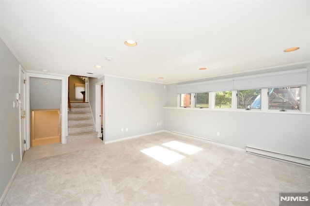 unfurnished room with a baseboard heating unit and light carpet