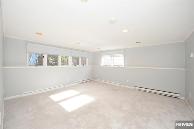 carpeted spare room with baseboard heating and crown molding