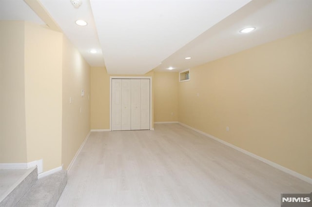 basement with light hardwood / wood-style flooring