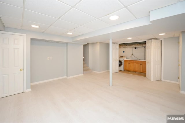 basement featuring a paneled ceiling and washer / clothes dryer