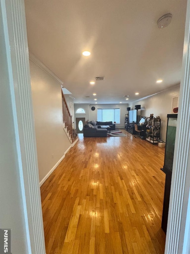 interior space with hardwood / wood-style flooring and ornamental molding