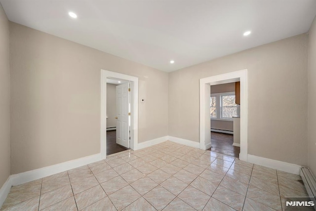 tiled spare room with a baseboard heating unit