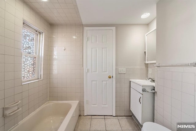 bathroom with tile patterned floors, vanity, and tile walls