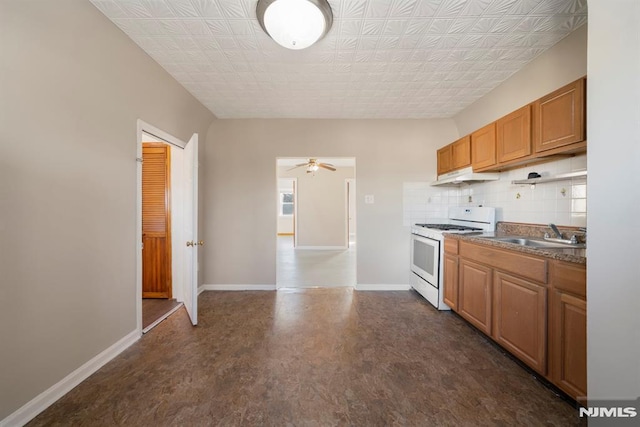 kitchen with backsplash, ceiling fan, sink, and white stove