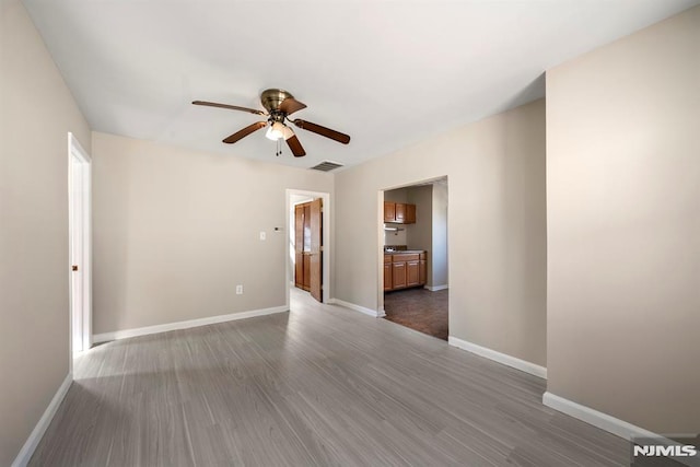 empty room with dark hardwood / wood-style floors and ceiling fan