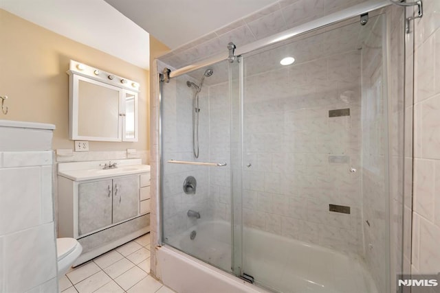 full bathroom featuring tile patterned flooring, vanity, bath / shower combo with glass door, and toilet