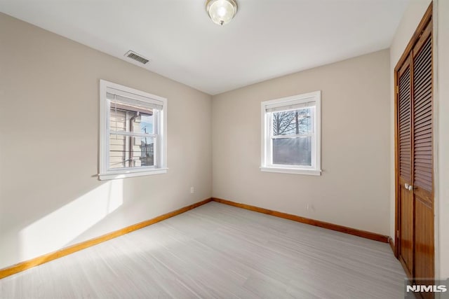 unfurnished bedroom featuring a closet and light wood-type flooring