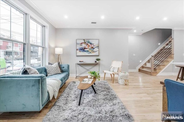 living room featuring light hardwood / wood-style floors and ornamental molding