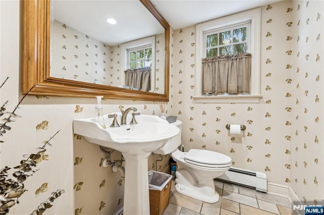 bathroom with baseboard heating, toilet, and tile patterned flooring