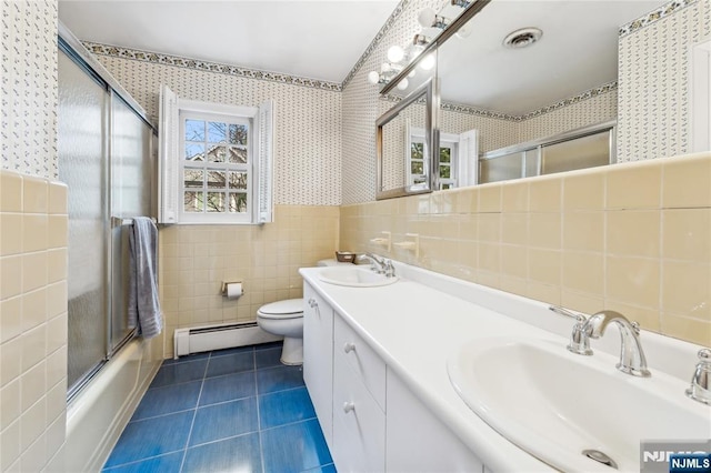 full bathroom with shower / bath combination with glass door, tile walls, a baseboard heating unit, tile patterned floors, and toilet