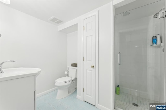 bathroom featuring tile patterned floors, toilet, a shower with shower door, and vanity